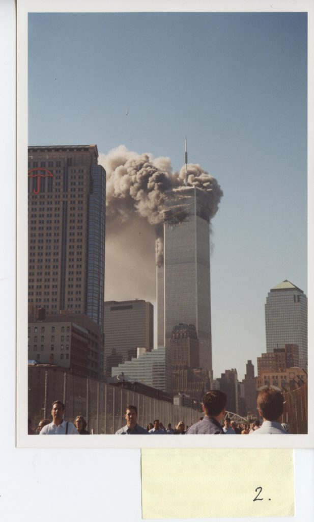 A photo of one of the WTC towers smoking. It's the same scene as the photo of the kid, but the perspective is higher and it shows more people looking back at the building.