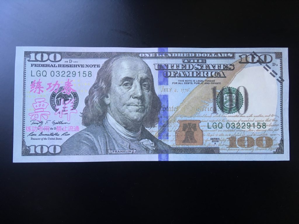 $100 bill with hot pink Chinese writing