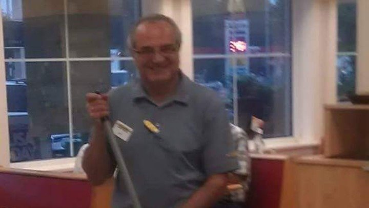 Blurry photo of a man smiling and holding what appears to be a broom