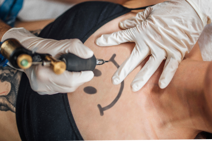 A person receiving a tattoo of the Underunderstood logo